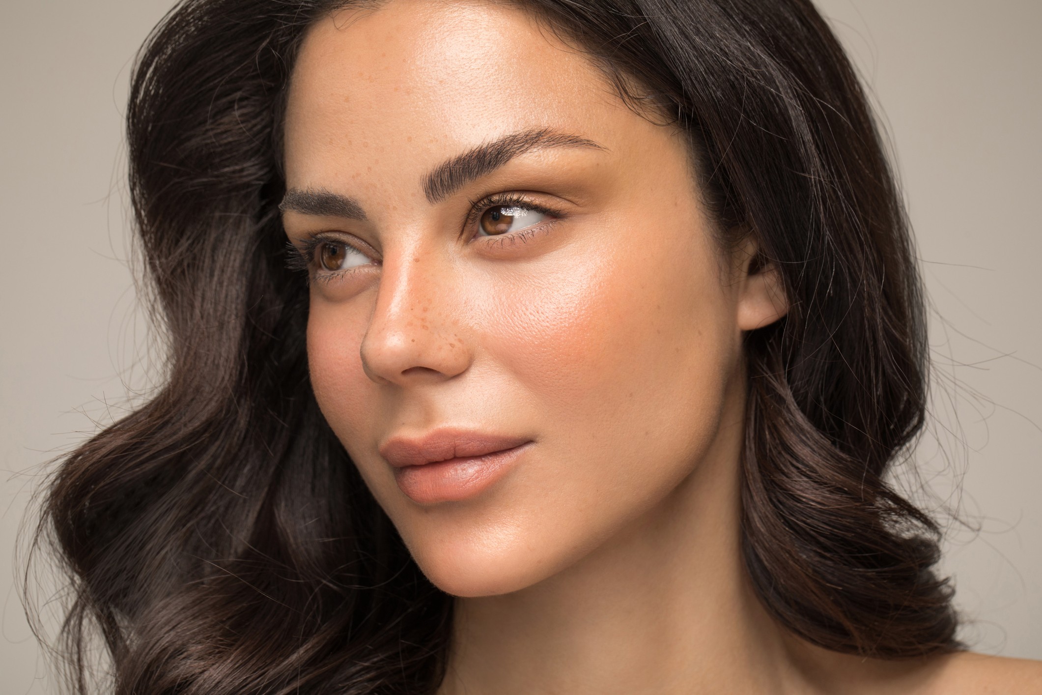 Close up studio shot of a beautiful natural blonde woman with freckles skin.